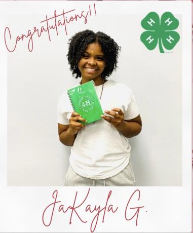 A teen girl holding a green notebook.